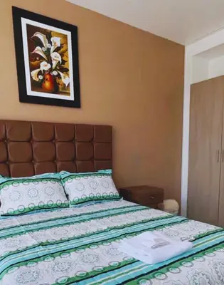 a bed in a bedroom with a picture on the wall at Hospedaje Mónaco - Jauja Airport in Jauja
