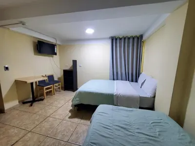 a hotel room with two beds and a desk at Jebas House in Cusco