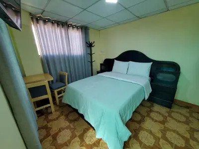 a bedroom with a bed and a table and a chair at Jebas House in Cusco