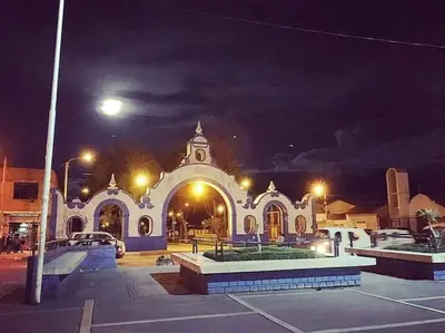 a large white building with a clock tower at night at Hospedaje Mónaco - Jauja Airport in Jauja