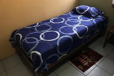 a blue comforter with white swirls on a bed at Departamento Completo en San Luis - Complete Apartment in San Luis in Lima