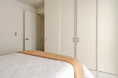 a bedroom with white cabinets and a bed at Vacation Escape - Elegant Barranco Stay near Beach & Art in Lima