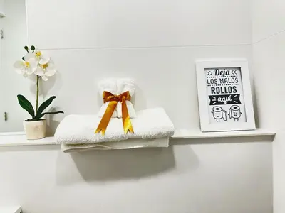 a pile of towels on a shelf with a bow at Vacation Escape - Elegant Barranco Stay near Beach & Art in Lima