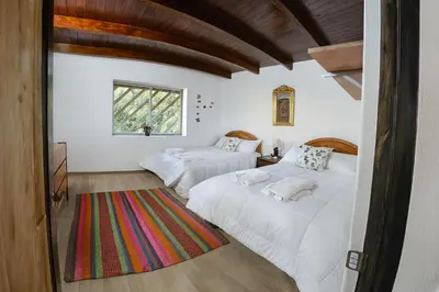 a bedroom with two beds and a window at La Casita de Orfi in Calca