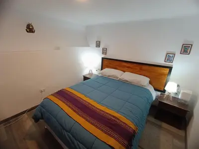 a bedroom with a large bed in a room at Mini Apart I - Sumaq Wasi Alba in Cusco