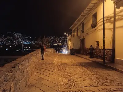a man walking down a street at night at Mini Apart I - Sumaq Wasi Alba in Cusco