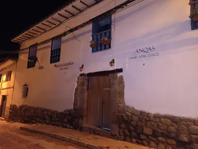 a white building with a door on the side at Mini Apart I - Sumaq Wasi Alba in Cusco
