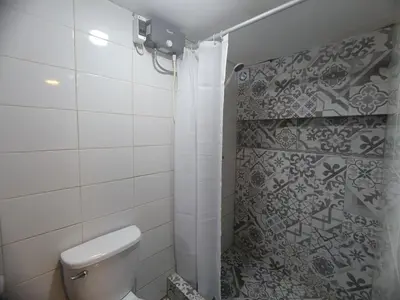 a bathroom with a toilet and a shower at Mini Apart I - Sumaq Wasi Alba in Cusco