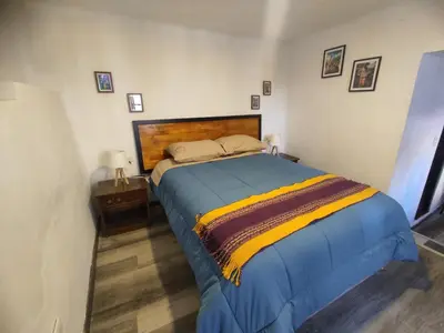 a bedroom with a bed with blue and yellow sheets at Mini Apart I - Sumaq Wasi Alba in Cusco