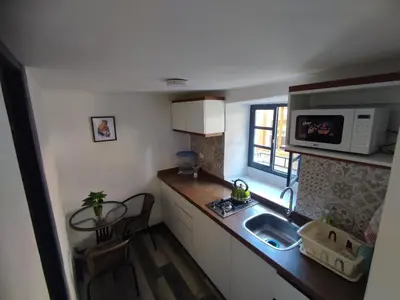 a small kitchen with a sink and a microwave at Mini Apart I - Sumaq Wasi Alba in Cusco