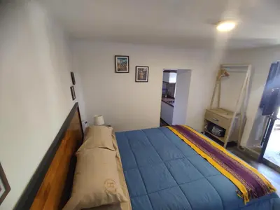 a bedroom with a bed with a blue comforter at Mini Apart I - Sumaq Wasi Alba in Cusco