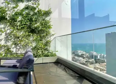 a person sitting in a chair on the top of a building at Great view and Pool apartment in Lima