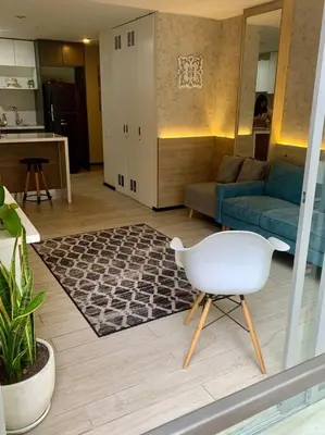 a living room with a white chair and a couch at Great view and Pool apartment in Lima