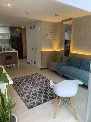 a living room with a blue couch and a white chair at Great view and Pool apartment in Lima