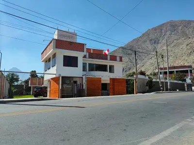 a building on the side of a street with a mountain at El Paraíso de Lunahuaná in Lunahuaná