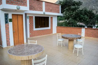 a patio with two tables and chairs and a building at El Paraíso de Lunahuaná in Lunahuaná
