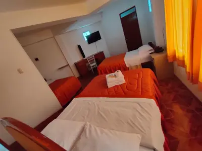 a hotel room with two beds and a television at El Paraíso de Lunahuaná in Lunahuaná
