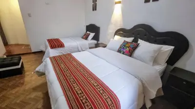 a bedroom with two beds with white sheets at Mallku Wasi - Lodging Hotel Cusco in Cusco