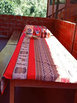 a wooden picnic table with a red blanket on it at Lucmabamba Dulcesueños Xiomara in Sahuayacu