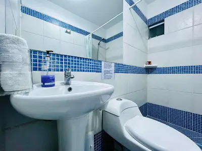 a blue and white bathroom with a sink and a toilet at Excelente ubicación, vista al mar, cerca a Costa 21 in Lima