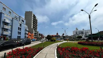 a city street with cars driving down a street with flowers at Excelente ubicación, vista al mar, cerca a Costa 21 in Lima