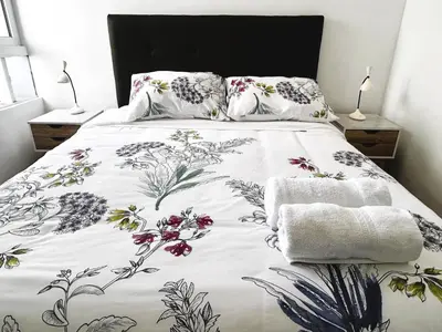 a bedroom with a bed with a floral bedspread at Excelente ubicación, vista al mar, cerca a Costa 21 in Lima