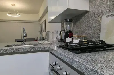 a kitchen with a stove and a counter top at Hermoso departamento con piscina, gimnasio, sala parrillas in Lima