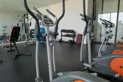 a gym with several treadmills and cardio machines at Hermoso departamento con piscina, gimnasio, sala parrillas in Lima