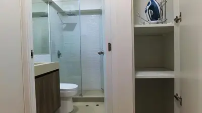 a bathroom with a toilet and a glass shower at Hermoso departamento con piscina, gimnasio, sala parrillas in Lima