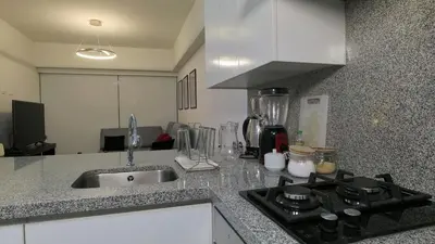 a kitchen with a sink and a stove top oven at Hermoso departamento con piscina, gimnasio, sala parrillas in Lima