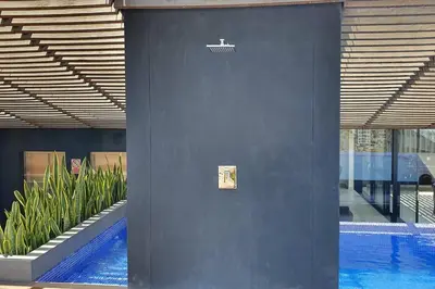 a blue wall next to a swimming pool with plants at Hermoso departamento con piscina, gimnasio, sala parrillas in Lima