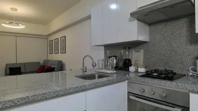 a kitchen with a sink and a counter top at Hermoso departamento con piscina, gimnasio, sala parrillas in Lima