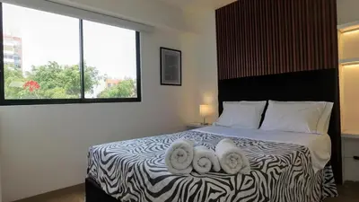 a bedroom with a bed with a pair of towel animals on it at Hermoso apartamento en San Isidro in Lima