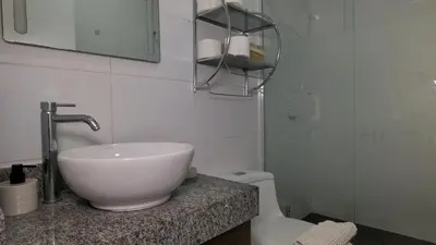 a white bathroom with a sink and a toilet at Hermoso apartamento en San Isidro in Lima