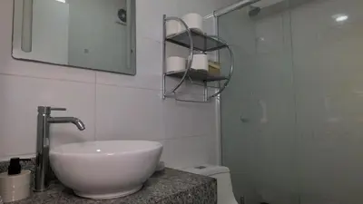 a white bathroom with a sink and a shower at Hermoso apartamento en San Isidro in Lima