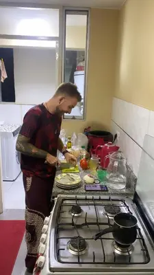 a man standing in a kitchen preparing food at Sai in Lima