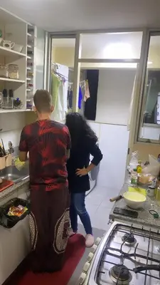 two children standing in a kitchen preparing food at Sai in Lima