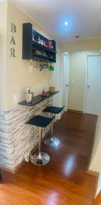 a room with two bar stools in front of a fireplace at Sai in Lima