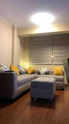 a living room with a couch and yellow pillows at Sai in Lima