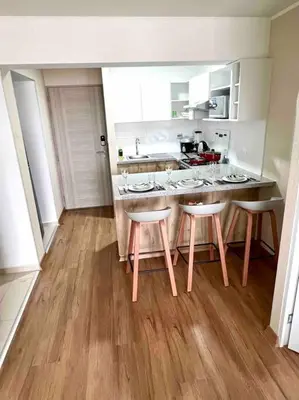 a kitchen with a table and four stools at Departamento estrenó céntrico a universidades in Lima