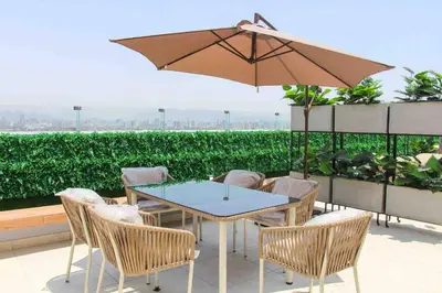 a patio with a table and chairs and an umbrella at Departamento estrenó céntrico a universidades in Lima