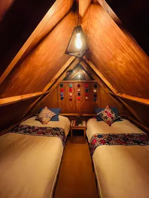 a bedroom with two beds in a room with a roof at SORAYPAMPA - Cabañas Andinas Mamá Andrea Eco Lodge in Soray