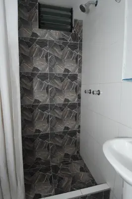 a bathroom with a tiled shower with a sink at Casa Medina Hostal in Cusco