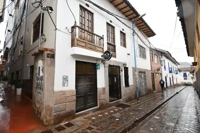 a street in an old town in the rain at Casa Medina Hostal in Cusco