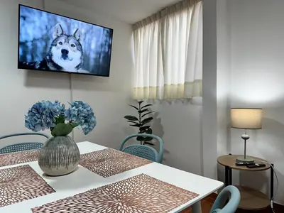 a dining room with a table with a tv on the wall at Bello depa San Miguel 3 camas 2 tv smart terraza in Lima
