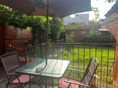 a table and chairs with an umbrella on a patio at Bello depa San Miguel 3 camas 2 tv smart terraza in Lima