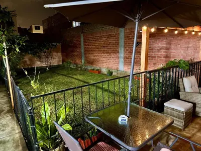 a patio with a table and an umbrella at Bello depa San Miguel 3 camas 2 tv smart terraza in Lima