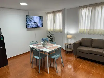 a living room with a table and chairs and a couch at Bello depa San Miguel 3 camas 2 tv smart terraza in Lima