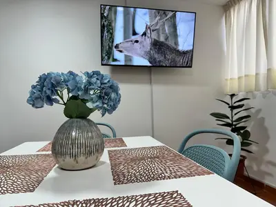 a table with a vase with blue flowers on it at Bello depa San Miguel 3 camas 2 tv smart terraza in Lima