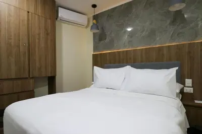 a bedroom with a white bed and a wooden wall at Dasso 167 by Wynwood House in Lima